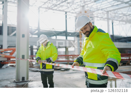Construction workers at work on modern building site. 126332118
