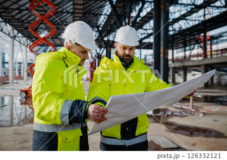 Construction managers reviewing project plans. 126332121