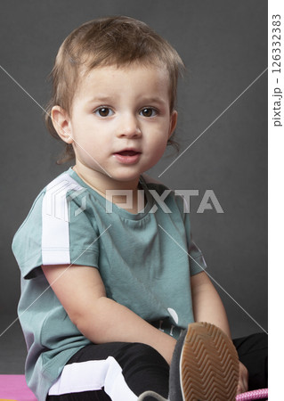 Portrait of a little funny girl, one and a half years old, wearing a sports T-shirt. Portrait of a little funny girl, one and a half years old, wearing a sports T-shirt. 126332383