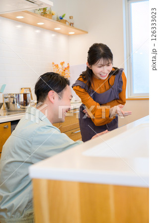 キッチンの設備を点検する作業服の男性と相談する女性 キッチンの設備を点検する作業服の男性と相談する女性 126333023