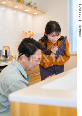 キッチンの設備を点検する作業服の男性と相談する女性 キッチンの設備を点検する作業服の男性と相談する女性 126333024