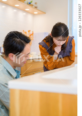 キッチンの設備を点検する作業服の男性と相談する女性 キッチンの設備を点検する作業服の男性と相談する女性 126333027