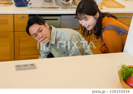 キッチンの設備を点検する作業服の日本人男性と女性 キッチンの設備を点検する作業服の日本人男性と女性 126333034