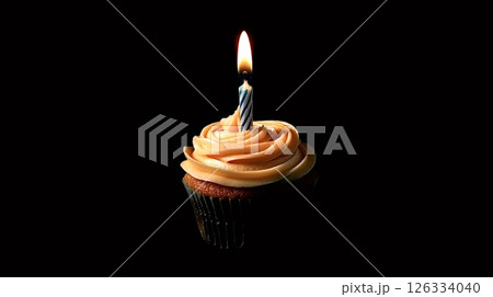 Single cupcake with lit birthday candle and swirled frosting on black background 126334040