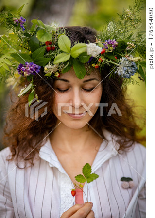 Woman with flower crown holding hands to chest, eyes closed in peaceful nature. Connection to femininity and earth energy through spiritual stillness Woman with flower crown holding hands to chest, eyes closed in peaceful nature. Connection to femininity and earth energy through spiritual stillness 126334080
