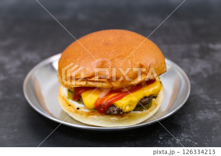 A cheeseburger is on a plate 126334213