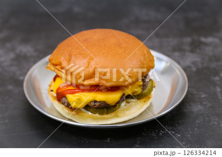 A cheeseburger is on a plate A cheeseburger is on a plate 126334214