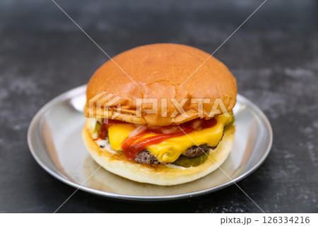 A cheeseburger is on a plate 126334216