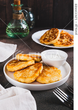 Crispy mashed potato pancakes and gravy on a plate on the table vertical view Crispy mashed potato pancakes and gravy on a plate on the table vertical view 126334489