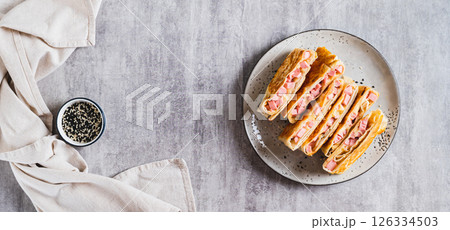 Crispy envelopes with sausage and cheese in flat bread on a plate top view web banner Crispy envelopes with sausage and cheese in flat bread on a plate top view web banner 126334503