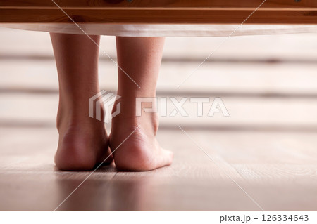 Legs of a young woman on a wooden floor, close-up 126334643