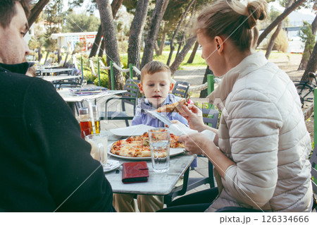 happy family eating pizza in cafe outside, lifestyle people happy family eating pizza in cafe outside, lifestyle people 126334666