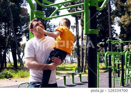 father with little son on the execising playground, lifestyle people concept father with little son on the execising playground, lifestyle people concept 126334700