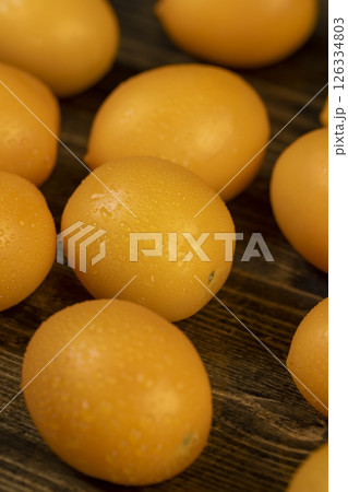 wet tomatoes of small size with soft flesh, yellow tomatoes covered with drops wet tomatoes of small size with soft flesh, yellow tomatoes covered with drops 126334803