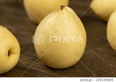 large yellow pears on the table , clean pears with yellow skins with small spots large yellow pears on the table , clean pears with yellow skins with small spots 126334804