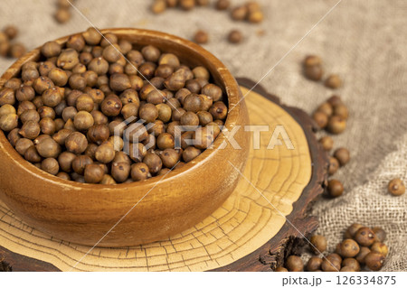 fried but not boiled chickpeas are on the table with a linen tablecloth, porridge is poured in a bowl, side view fried but not boiled chickpeas are on the table with a linen tablecloth, porridge is poured in a bowl, side view 126334875