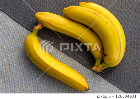 bunch of ripe bananas on the gray background with early morning sunlight shines through bunch of ripe bananas on the gray background with early morning sunlight shines through 126334931