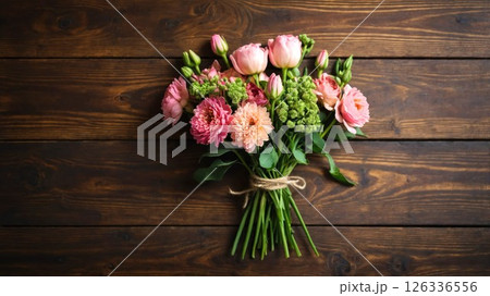 A beautiful bouquet of pink flowers displayed elegantly on a wooden table A beautiful bouquet of pink flowers displayed elegantly on a wooden table 126336556