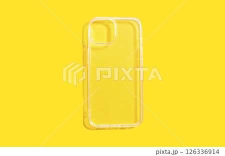 Transparent phone case on bright yellow background, showcasing clean design and clarity, ideal for smartphone protection and aesthetic appeal, with copy space for customization 126336914