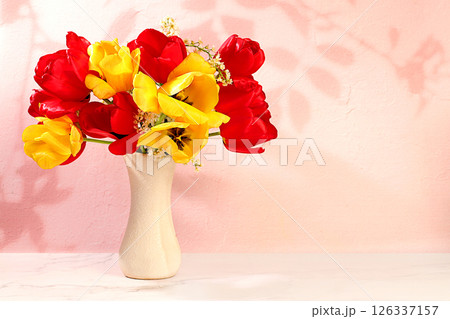 Abstract flower arrangement and banner for screen, Still life,Beautiful spring blooming tulips and cherries in vase on elegant background. Floral holiday card with summer greeting concept 126337157
