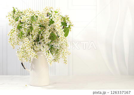 Abstract floral arrangement and banner for screen, Still life with beautiful spring branches of blooming bird cherry in vase on elegant background.Floral holiday card with summer greeting concept 126337167