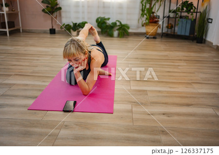 Practicing yoga and mindfulness in a cozy home environment 126337175
