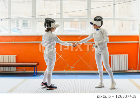 Female fencers shaking hands after match 126337419