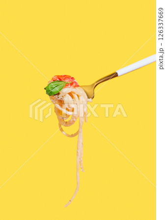 Fork with creamy spaghetti, tomato and basil on isolated bright yellow background. 126337669