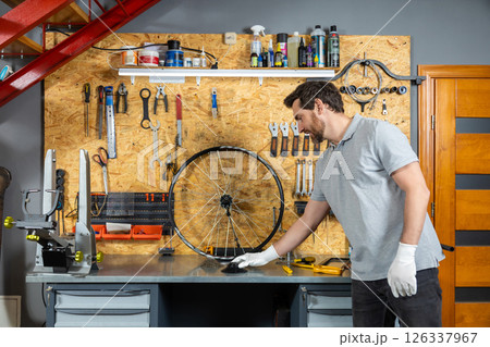 Mechanic in white gloves working on wheel Mechanic in white gloves working on wheel 126337967