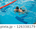 Man in black swimming cap swimming crawl style in the pool 126338179