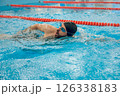 Man in black swimming cap swimming crawl style in the pool 126338183
