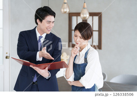 物件案内する不動産営業マンと開業する女性 物件案内する不動産営業マンと開業する女性 126338506