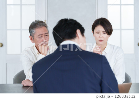 打ち合わせする営業マンと親子の客 126338512