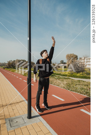 Man Trying To Stop A Taxi While Waiting Outdoor To Return Home  126339328