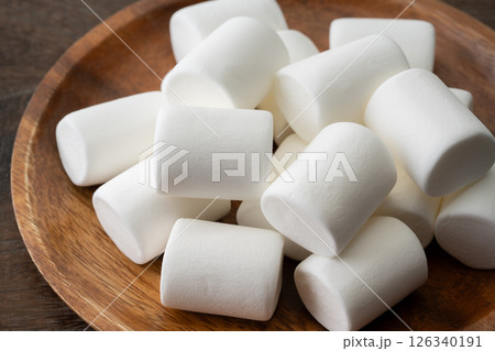 木のお皿に載せた白いマシュマロのクローズアップ 126340191
