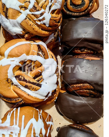 baked treats displayed in cozy bakery featuring sweet rolls and chocolate pastries. close-up. 126340272