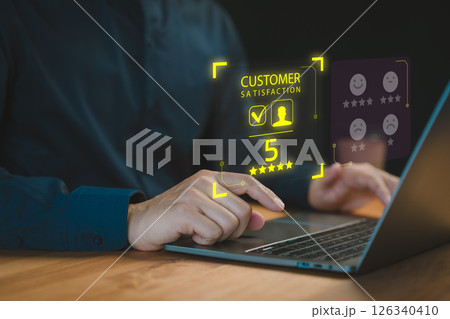 A professional user interacts with a laptop, displaying a virtual interface for customer satisfaction ratings and reviews with a highlighted 5-star rating. A professional user interacts with a laptop, displaying a virtual interface for customer satisfaction ratings and reviews with a highlighted 5-star rating. 126340410