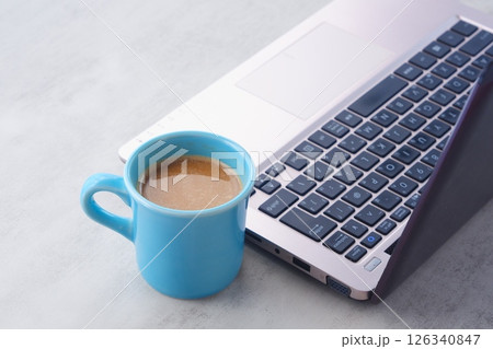 淹れたての美味しいコーヒー、カフェ・ラッテを飲みながら、ノートパソコンでデスクワーク中のイメージ 淹れたての美味しいコーヒー、カフェ・ラッテを飲みながら、ノートパソコンでデスクワーク中のイメージ 126340847