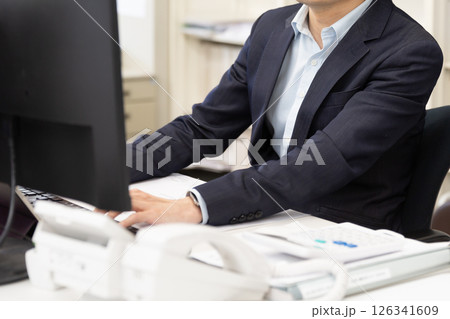 デスクのパソコンで仕事をする男性ビジネスマン デスクのパソコンで仕事をする男性ビジネスマン 126341609