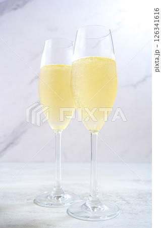 2脚のフルートグラスに冷えたシャンパン(スパークリングワイン)を注いで、乾杯するイメージ 2脚のフルートグラスに冷えたシャンパン(スパークリングワイン)を注いで、乾杯するイメージ 126341616