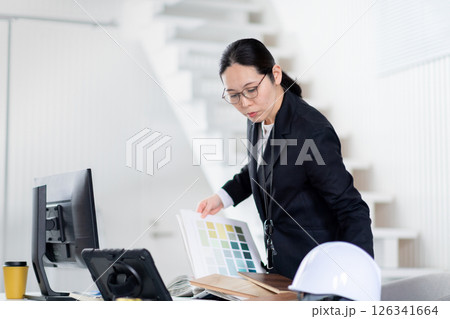 建材と資料をひろげて作業をする建設会社の女性社員 建材と資料をひろげて作業をする建設会社の女性社員 126341664