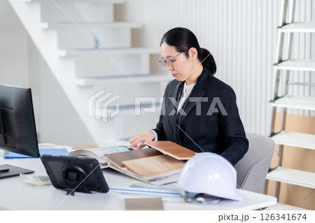 建材と資料をひろげて作業をする建設会社の女性社員 126341674