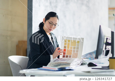 建材サンプルと資料を並べて作業する建設会社の女性社員 建材サンプルと資料を並べて作業する建設会社の女性社員 126341727