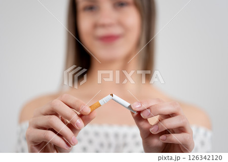 Close-up of woman hands breaking cigarette. quit smoking concept Close-up of woman hands breaking cigarette. quit smoking concept 126342120
