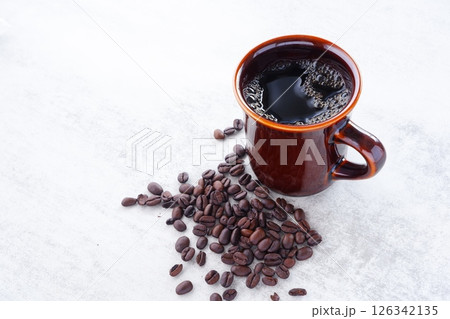 淹れたてで香りのよいコーヒーが入ったマグカップと、深煎りのコーヒー豆 淹れたてで香りのよいコーヒーが入ったマグカップと、深煎りのコーヒー豆 126342135