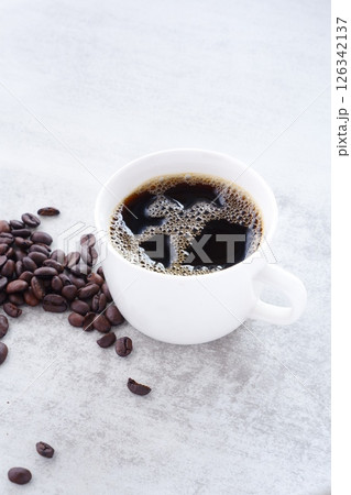 淹れたてで香りのよいコーヒーが入ったマグカップと、深煎りのコーヒー豆 淹れたてで香りのよいコーヒーが入ったマグカップと、深煎りのコーヒー豆 126342137