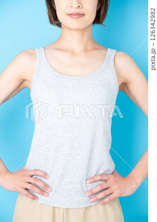 腰に手を当てて微笑むタンクトップのミドル女性 126342982