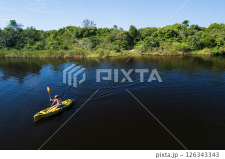 Happy active kids have a fun on yellow kayak in sea lagoon.  Healthy lifestyle. Recreational water sport, kayaking tour in adventure camp on family summer beach vacation 126343343