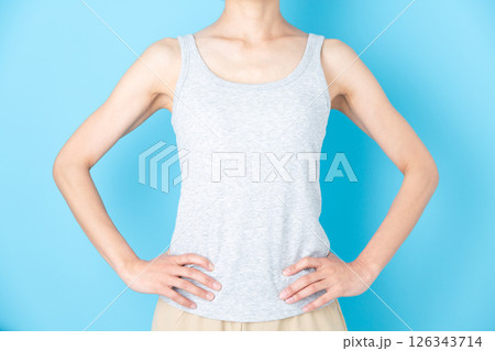 腰に手を当てるタンクトップのミドル女性 126343714