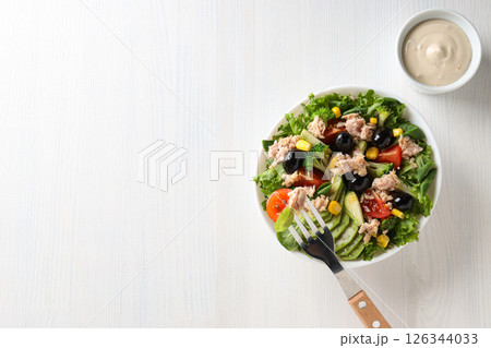 Salad with tuna on a white table. Salad with tuna on a white table. 126344033